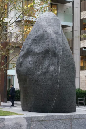 large dark boulder with engraved inscriptions in various languages
