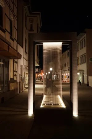 fountain system with integrated water curtain photographed at night