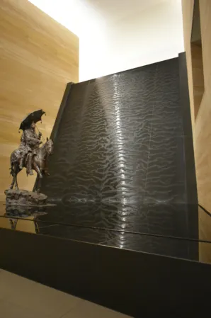 water wall made of black granite with a sculpture in front