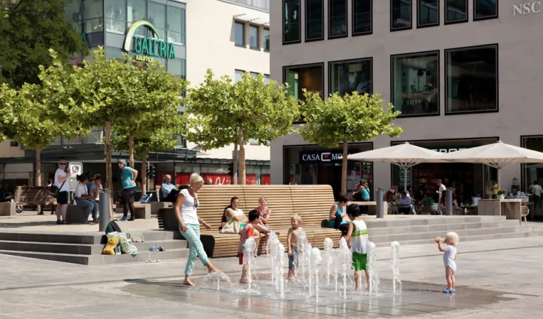 fountain field in summer with playing children