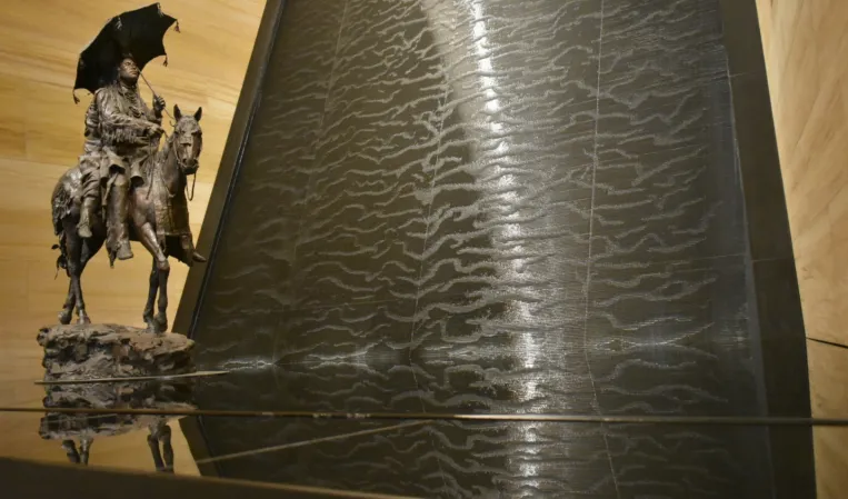 water wall made of black granite with a sculpture in front
