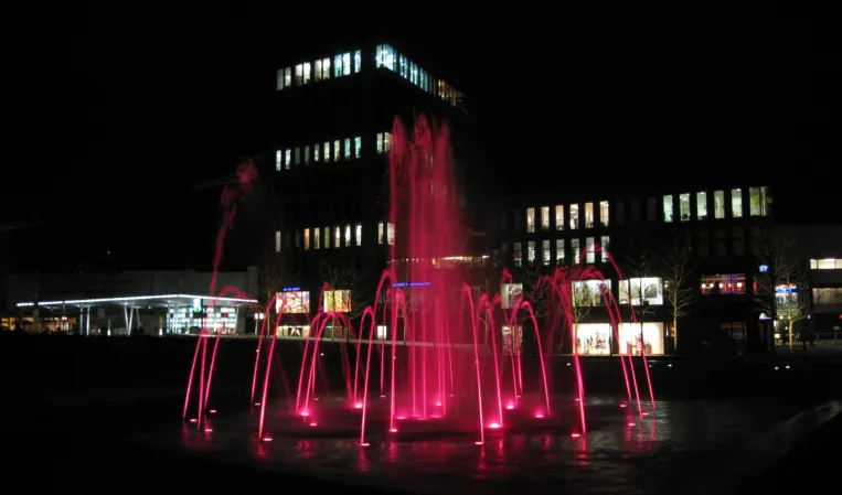 large water fountains lit red at night