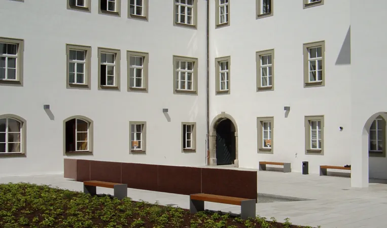 Red waterwall inside a historic courtyard