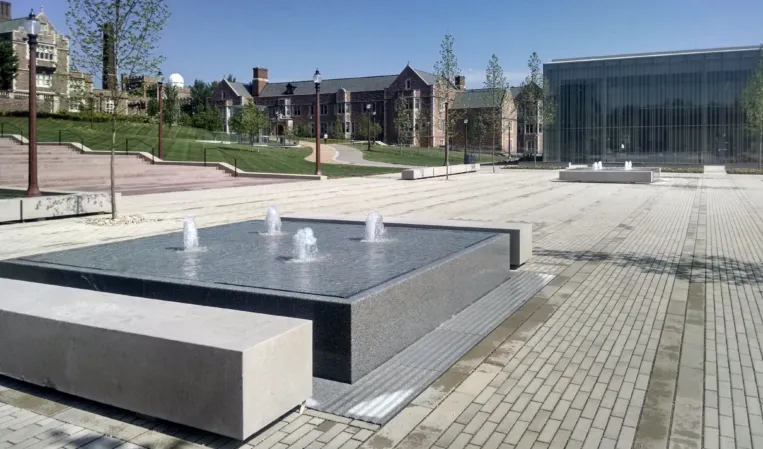 fountain with jets with an American university in the background