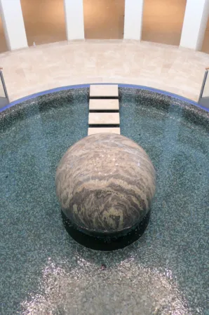 Large natural stone sphere with stepping stones in a fountain installation