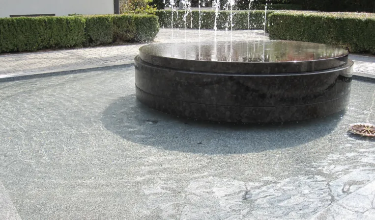 Rotating disc made of black granite with fountains