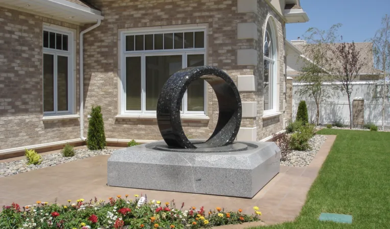 Rotating ring made of black granite in a fountain installation