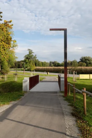 Cycle path bridge with burgundy railing and large streetlight