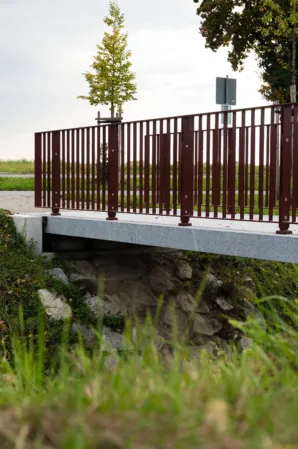 Burgundy railing surface-mounted on a granite bridge