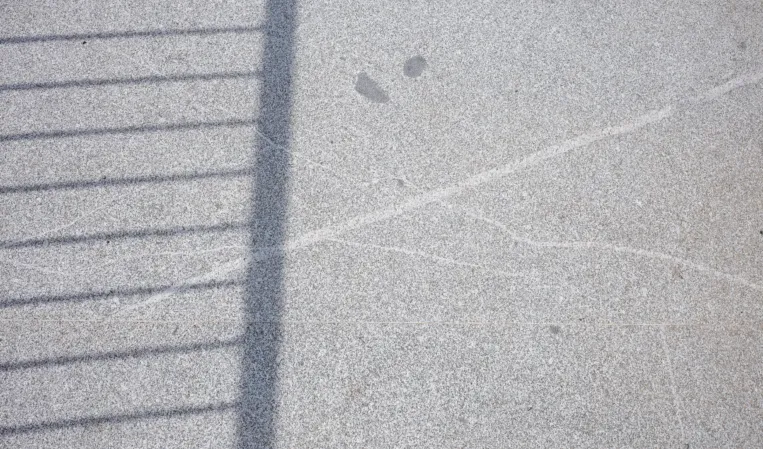 Texture of a granite bridge with the shadow of a railing