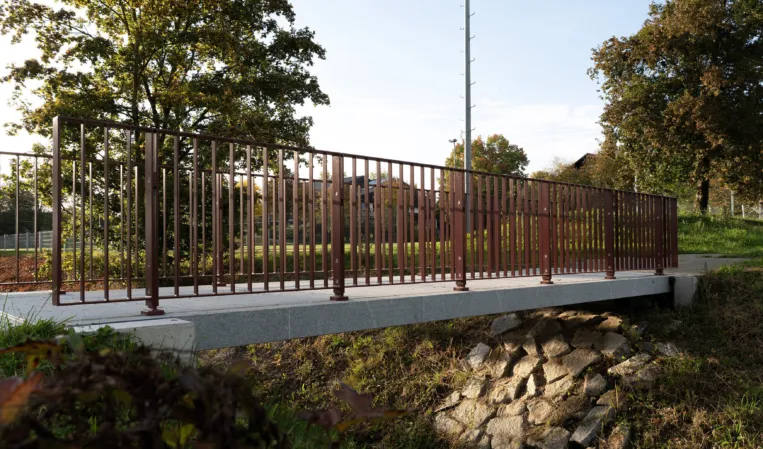Pedestrian bridge with burgundy railing