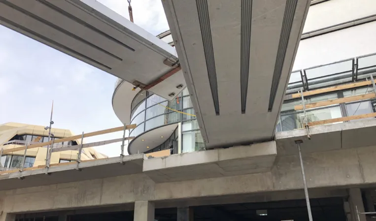 Two post-tensioned granite bridges being installed in an urban setting