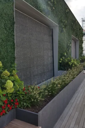 Water wall made of dark granite with surrounding green wall