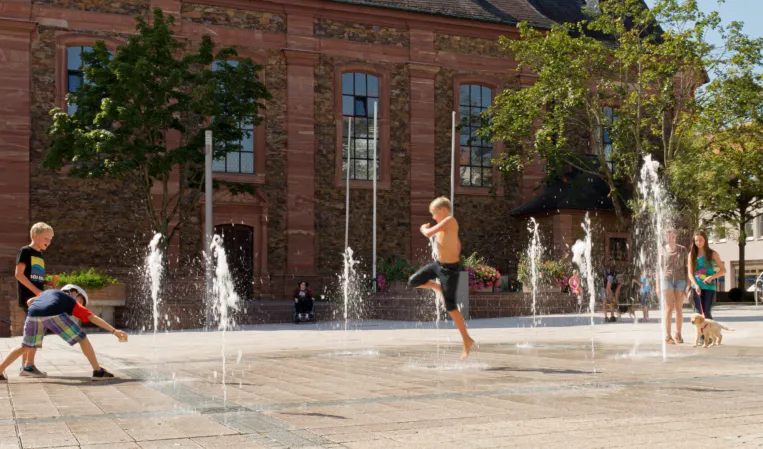 Children playing on a water jet field