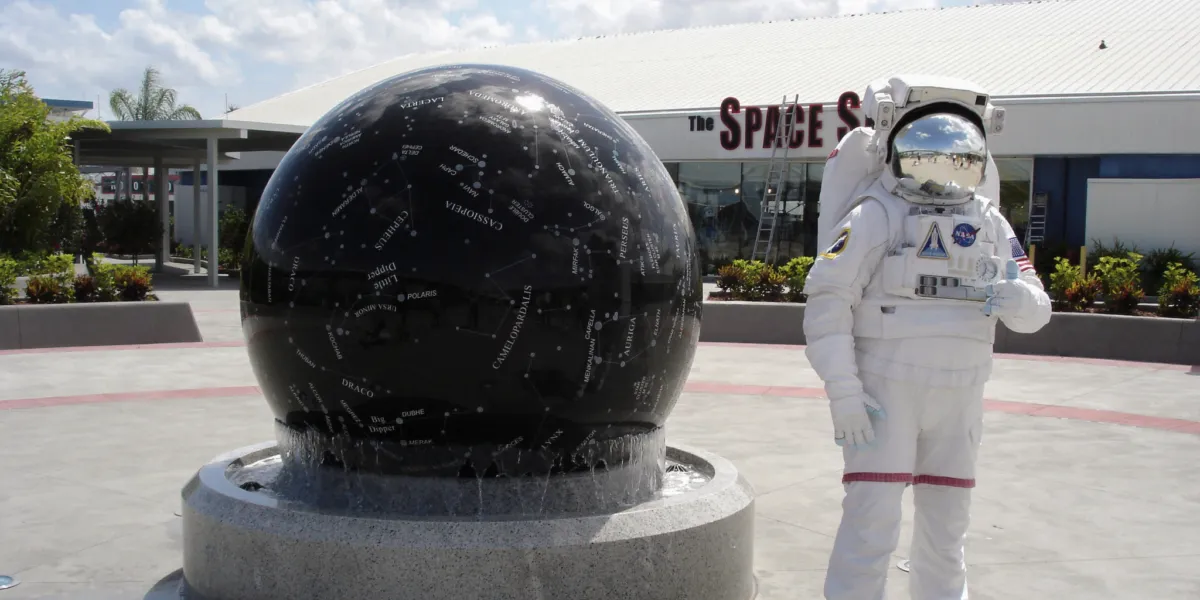 black floating sphere next to an astronaut