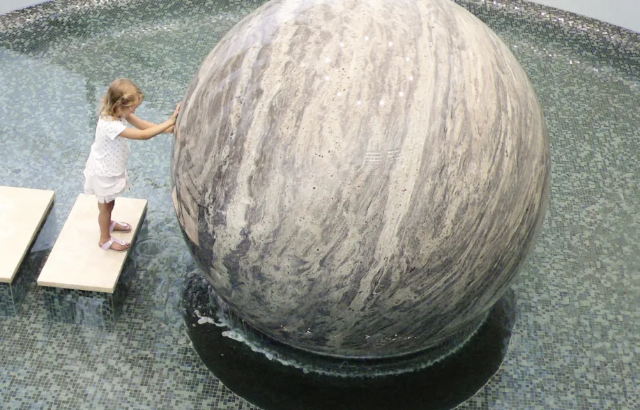 a child moves a giant granite sphere