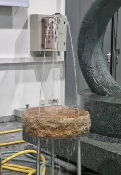 A mockup of a chair made from granite with a water jet in the center