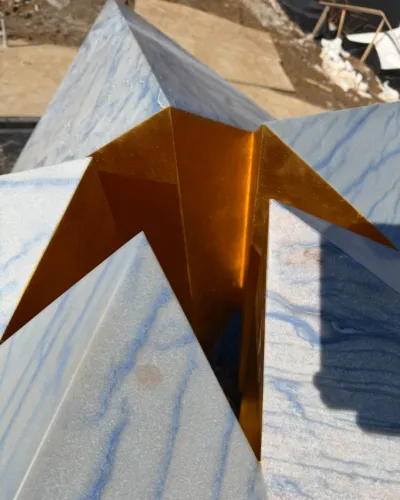 Angular sculpture on a veined blue marble surface.