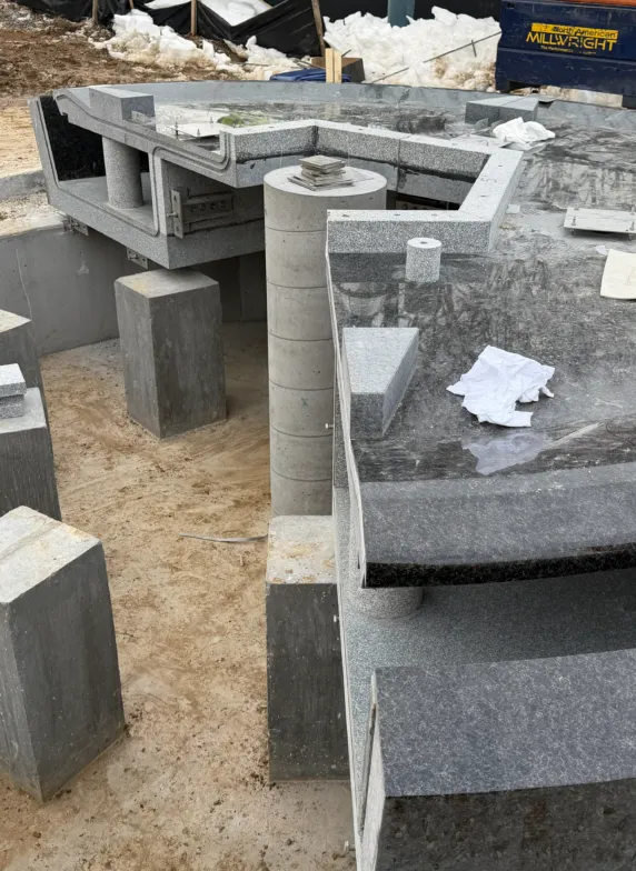 Granite components and prefabricated stone elements arranged at a construction site