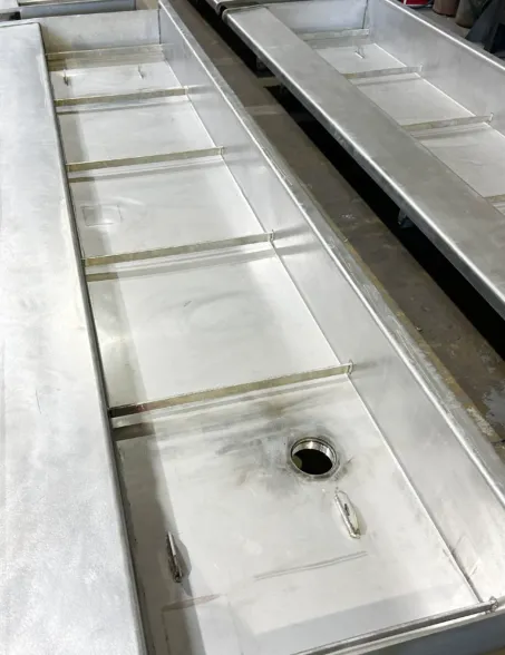 Stainless steel basin with integrated drainage for a water wall fountain