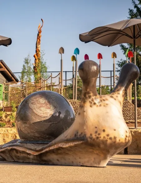 Polished granite sphere fountain representing a snail in an outdoor playground