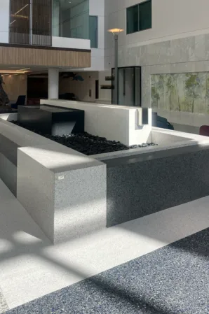 Modern granite fountain with geometric stone blocks and a rectangular water basin in a contemporary courtyard