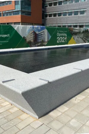 Close-up of a rectangular granite reflecting pool with dark water and light stone edges