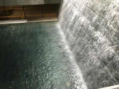 Large indoor waterfall cascading into a dark reflecting pool