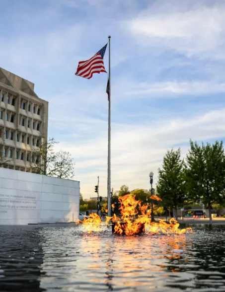 fire feature in the center of a reflecting pool
