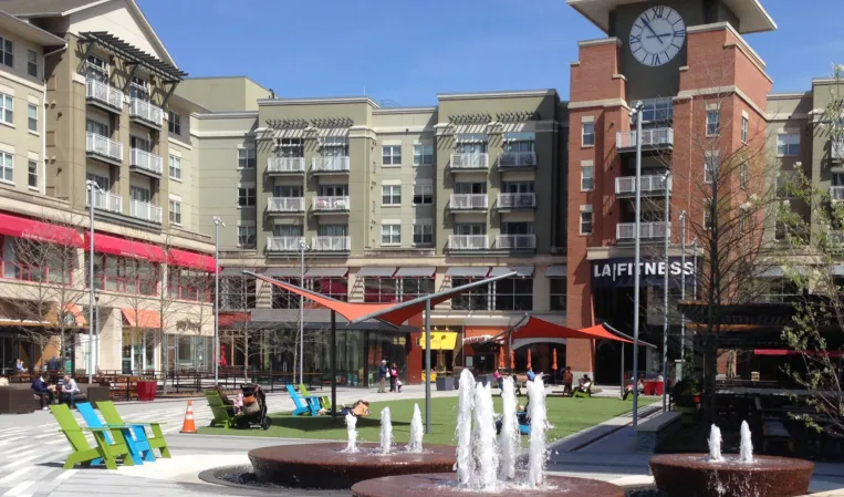 Circular fountains with water jets and outdoor seating in a modern shopping plaza