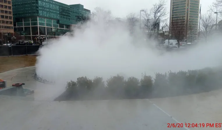 Interactive fog fountain filling an urban plaza with dense mist from programmable fog jets