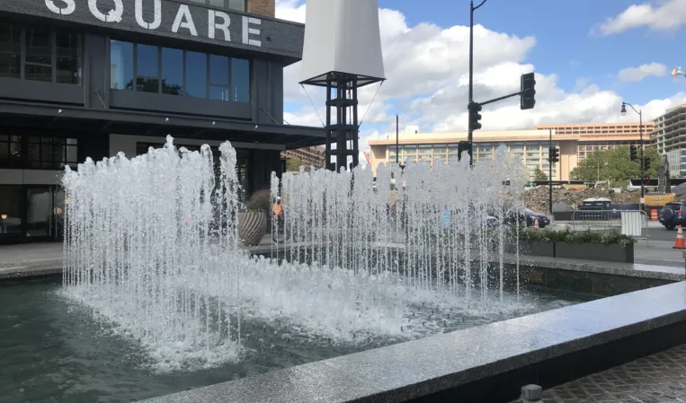 Rectangular granite fountain with rows of water jets in an urban plaza