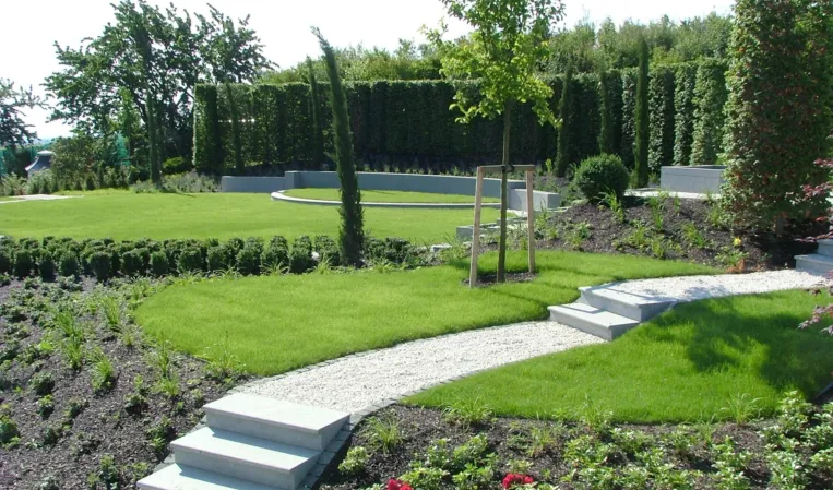 Landscaped garden with granite steps and winding stone pathways surrounded by greenery
