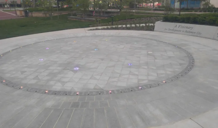 Circular interactive fog fountain with embedded colored lights and drainage channels at the Theodore Roosevelt Memorial