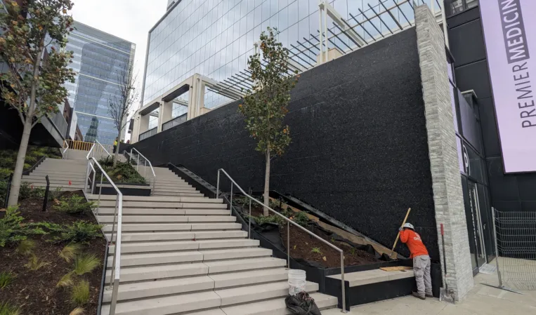 Large water wall next to a staircase leading into an office building