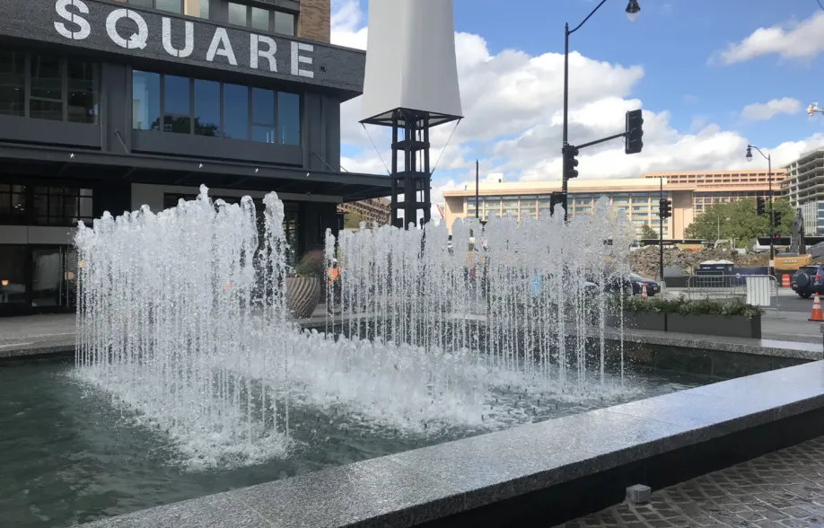 Rectangular granite fountain with rows of water jets in an urban plaza