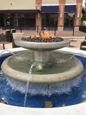 Tiered stone fountain with a central fire feature and water cascading into a blue-tiled basin