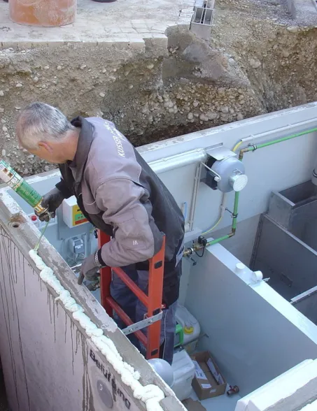 Technician installing water technology equipment inside a concrete vault