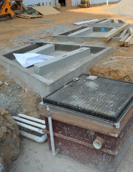 Prefabricated granite fountain components and drainage system at a construction site