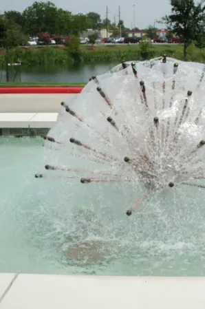 Close-up of a spherical water feature with multiple jets spraying into a fountain basin
