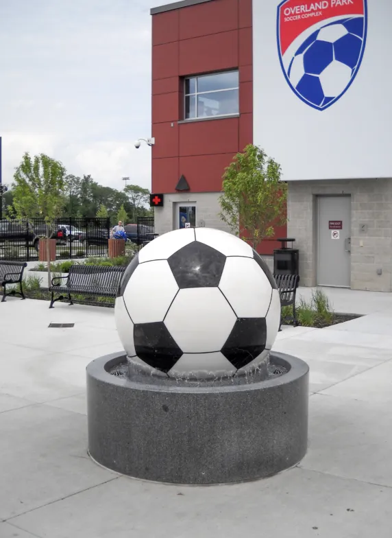 Granite sphere fountain shaped like a soccer ball outside a sports complex