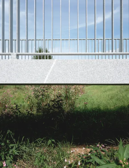 side view of a post-tensioned granite bridge with a surface mounted railing